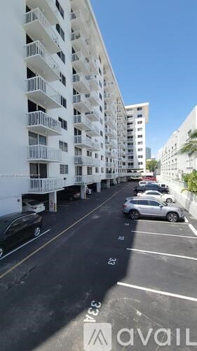 A parking lot with cars and apartment buildings.
