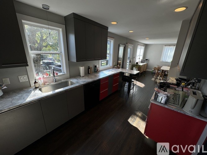A kitchen with a sink, cabinets, and a window.