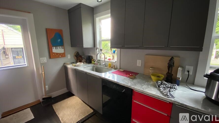 A kitchen with a sink, stove, and a window.