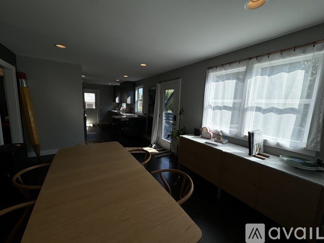 A modern kitchen with a long wooden table in the foreground.