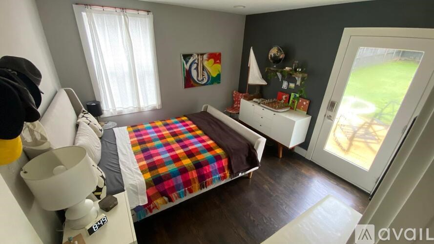 A bedroom with a bed, a dresser, and a window.