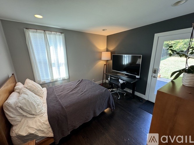 A bedroom with a bed, desk, and chair.