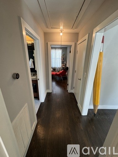 A hallway with a yellow umbrella leaning against the wall.