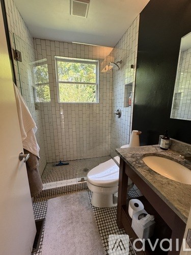 A bathroom with a toilet, sink, and shower.