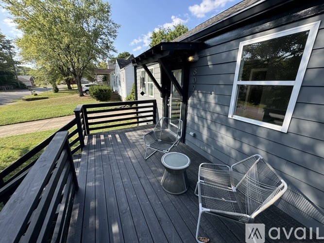 A wooden deck with a bench and a table.