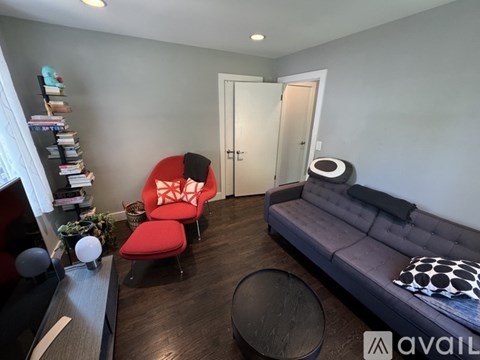 A living room with a red chair and a grey sofa.
