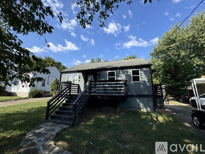 A house with a grey exterior and a black staircase leading to the front door.