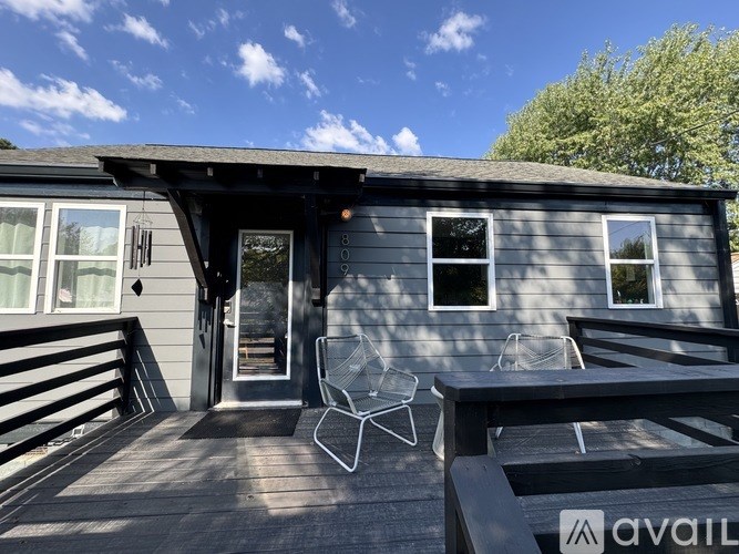 A house with a grey exterior and a wooden deck.