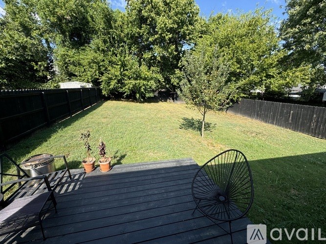 A backyard with a deck and a tree.