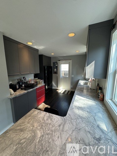 A kitchen with a marble countertop and a refrigerator.