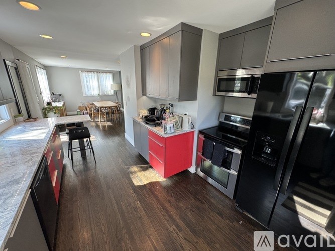 A kitchen with a black fridge and a red island.