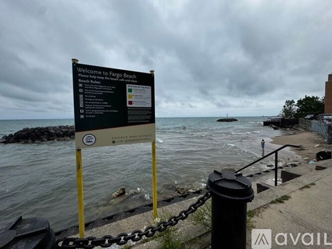 A sign welcoming visitors to Fargo Beach is displayed on a cloudy day.