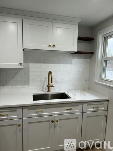 A kitchen with white cabinets and a sink.