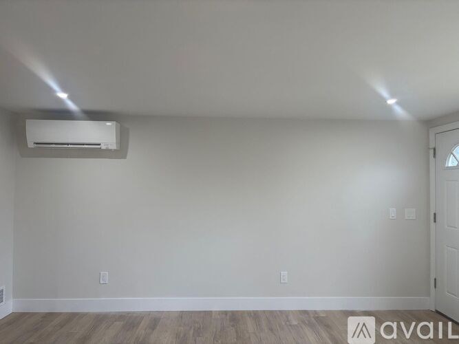 A room with a white wall and a door on the right side.