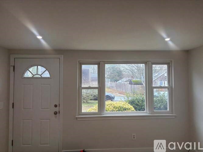 A white door with a window above it in a room.
