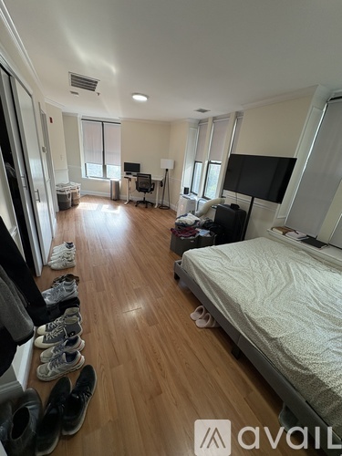 A bedroom with a bed, a desk, and a chair.