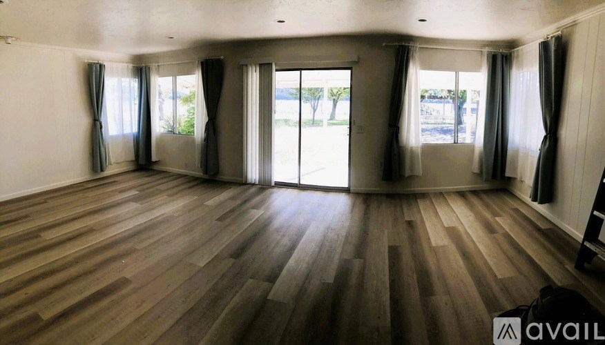 A room with wooden flooring and sliding glass doors.