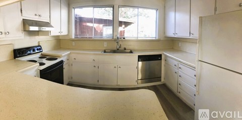 A kitchen with white cabinets and appliances.