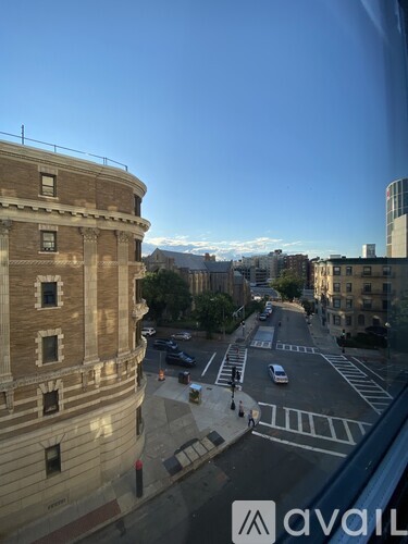 A view from a window of a street with cars and buildings.