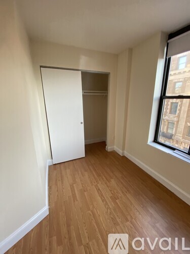 A room with wooden flooring and a white door.