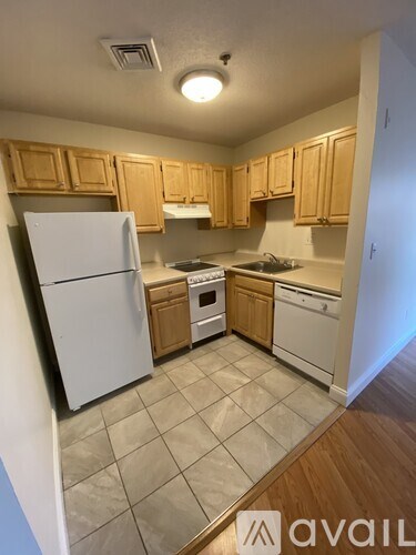A kitchen with wooden cabinets and white appliances.