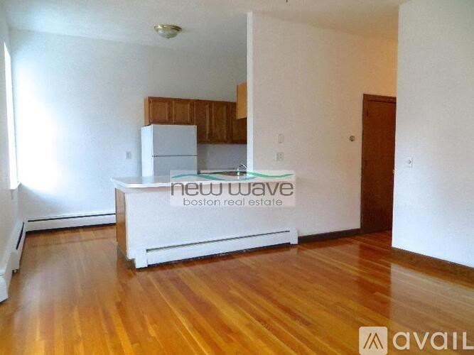 A kitchen with white appliances and wooden cabinets is available for rent.