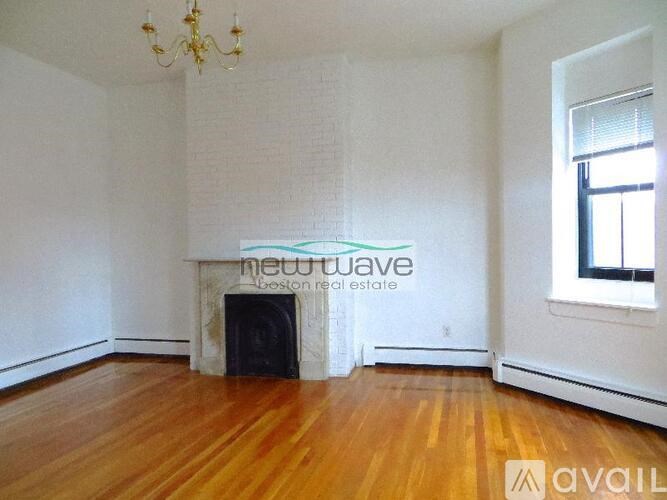 A room with a fireplace and wooden floors is available for rent.