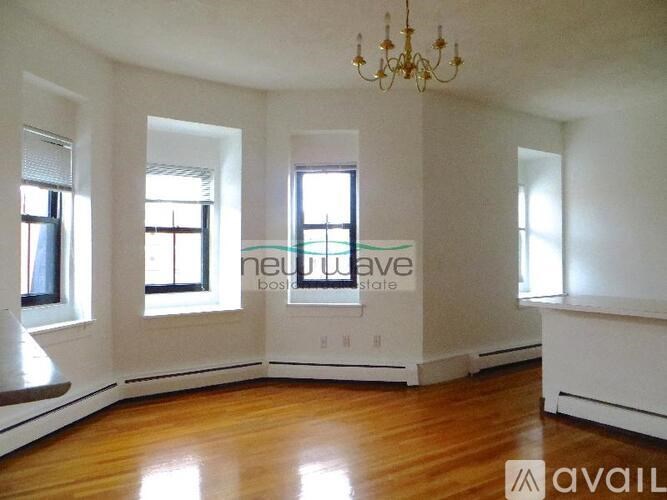 A room with a chandelier and a window with a view of the city.