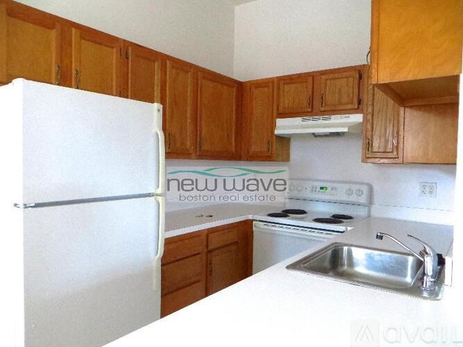 A kitchen with wooden cabinets and a white fridge.