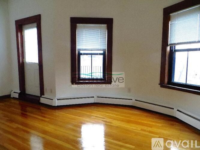 A room with wooden floors and two windows.