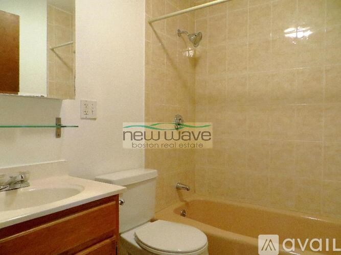 A bathroom with a tub, toilet and sink.