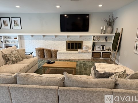 A living room with a large couch and a fireplace.