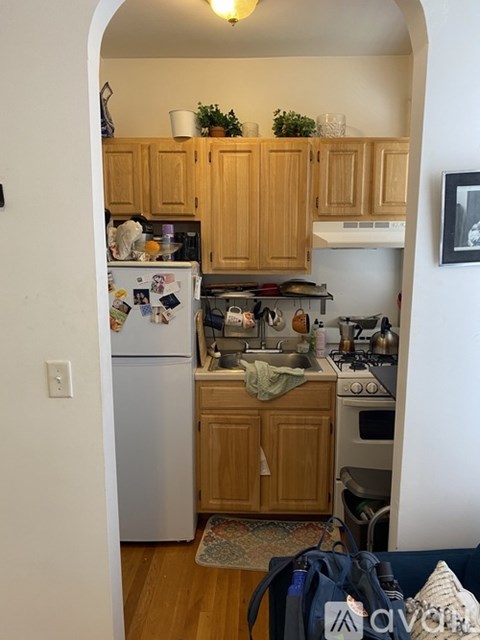 A kitchen with wooden cabinets and a white refrigerator.
