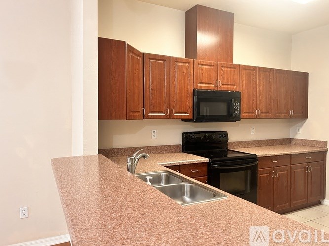 A kitchen with brown cabinets and a granite countertop.