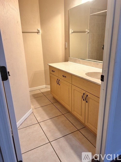 A bathroom with a sink, mirror, and cabinets.
