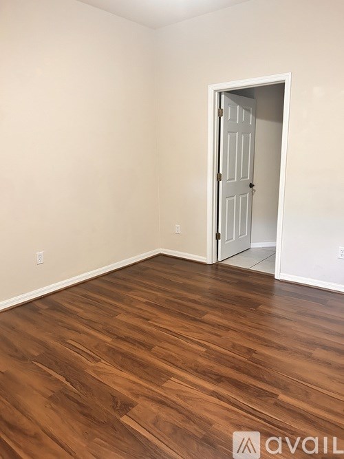 A room with a wooden floor and a white door.
