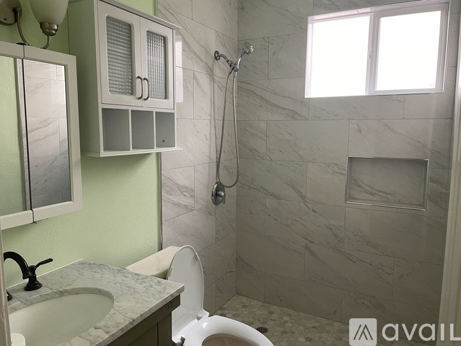 A bathroom with a green wall and a marble countertop.