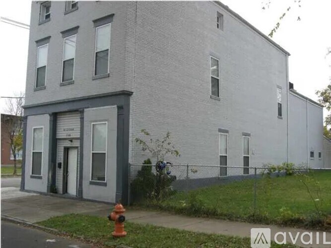 A grey building with a white door and windows.