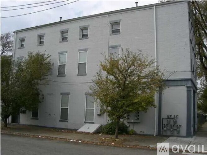 A grey building with a tree in front of it.