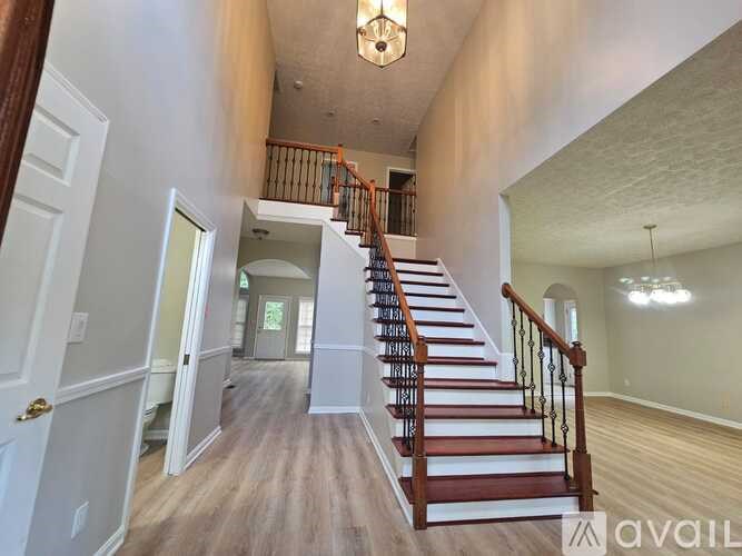 A hallway with a staircase leading to the second floor.