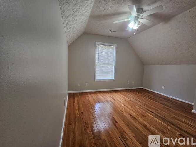 A room with wooden floors and a ceiling fan.