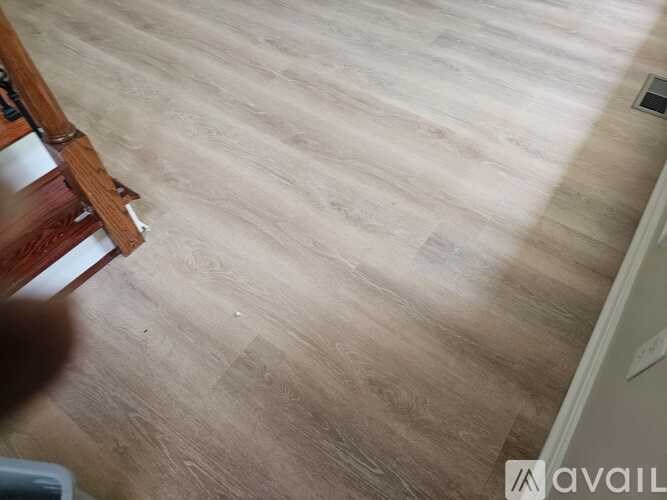 A room with a wooden floor and a white wall.