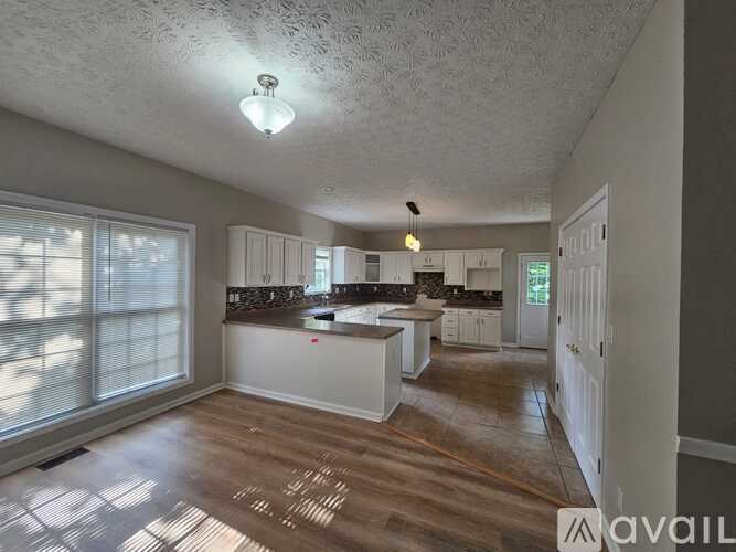 A spacious kitchen with white cabinets and a large island.