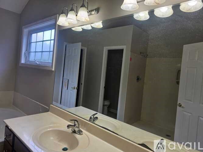A bathroom with a sink, mirror, and lights.