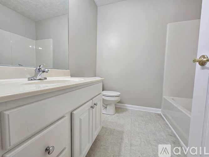 A bathroom with a toilet, sink, and bathtub.