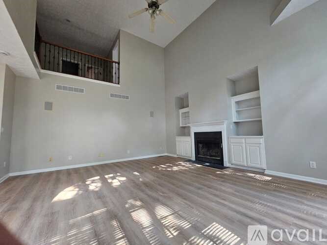 A living room with a fireplace and a ceiling fan.