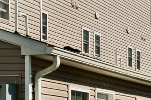 a row of houses with white siding and green grass