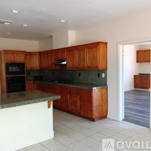 A kitchen with wooden cabinets and granite countertops.