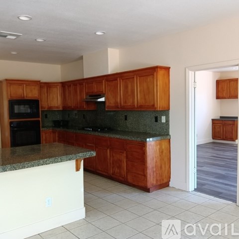 A kitchen with wooden cabinets and granite countertops.