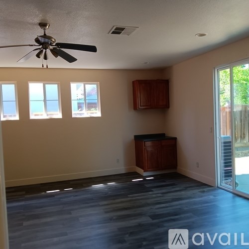 A room with a ceiling fan and a cabinet.